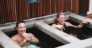 Two people taking a dip in an ice bath to improve their mental health and resilience