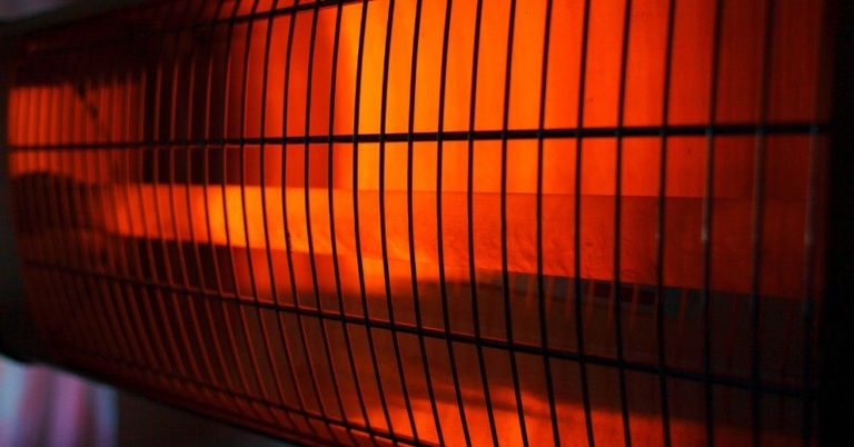 Close-up of an electric heater glowing orange, like those used in an infrared sauna session.