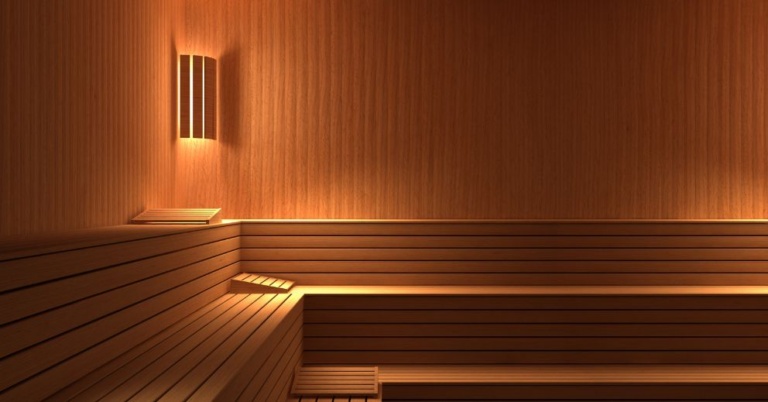 Empty wooden sauna room with tiered benches, ideal as a sauna for sore joints and relaxation.